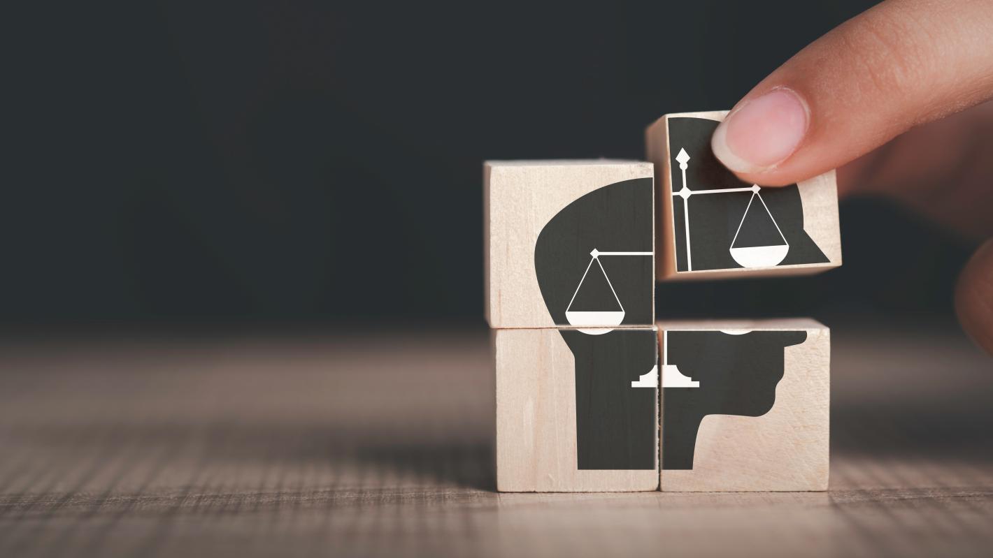  image shows a hand placing the final piece of a puzzle which contains an icon of a balanced scale, symbolizing justice and accountability