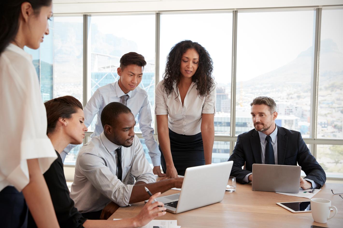 The image shows a group of five individuals in a professional setting, suggesting a discussion related to human resources
